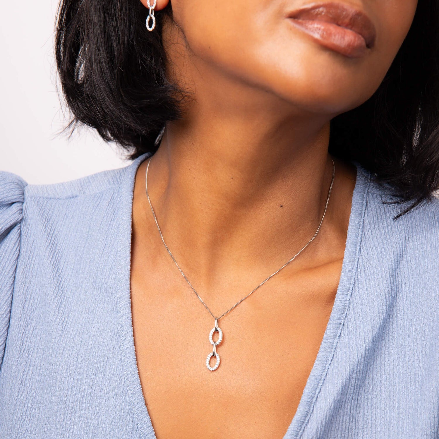 Cubic zirconia oval link drop pendant and chain in silver.